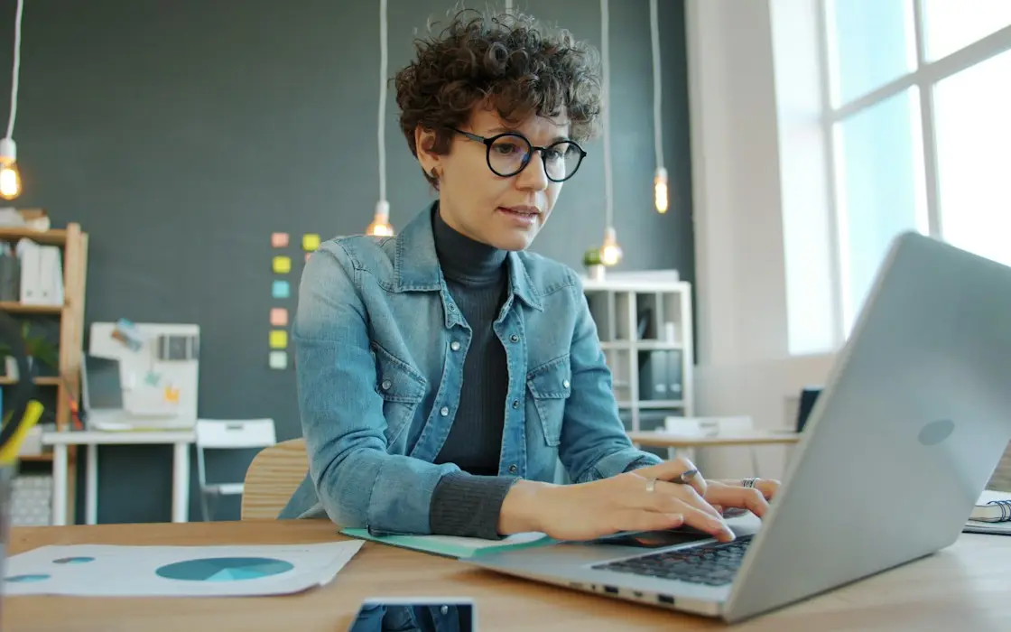 A woman writing on a laptop in a bright office
